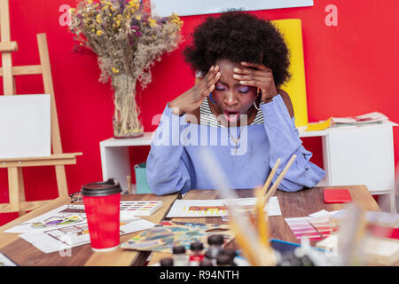 Beautiful stylish designer yawning after long day at work Stock Photo