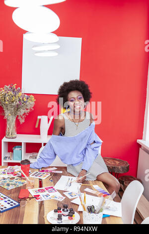 Smiling designer wearing massive earrings smiling broadly Stock Photo