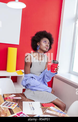 Stylish interior designer feeling bored while working alone in office Stock Photo