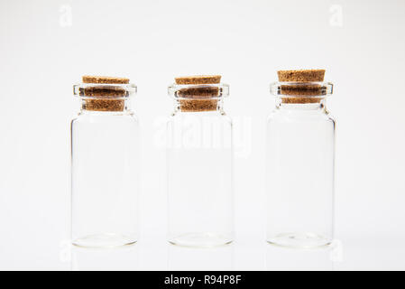 Empty little bottles with cork stopper on white background, close-up Stock Photo