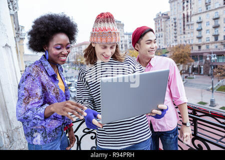 Programmer with long blonde hair showing his project to friends Stock Photo
