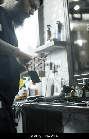 The male hands and tools for cutting beard at barbershop. Vintage tools of barber shop Stock Photo