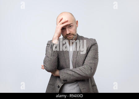 European bald man depressed with hand on his head Stock Photo
