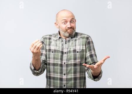 Mature european man explaining something simple being questioned someone, frowning and grimacing Stock Photo