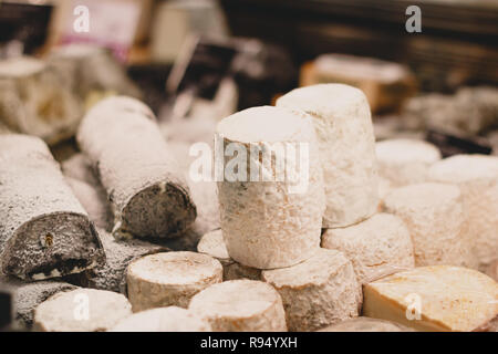 Sainte-Maure de Touraine and chevre cheeses on a showcase in a French grocery shop. Stock Photo