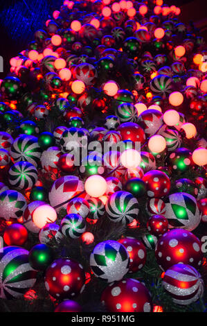 Many Christmas tree decorations lit up in different colors Stock Photo