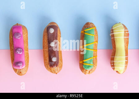Closeup top view of eclairs on pink-blue background Stock Photo