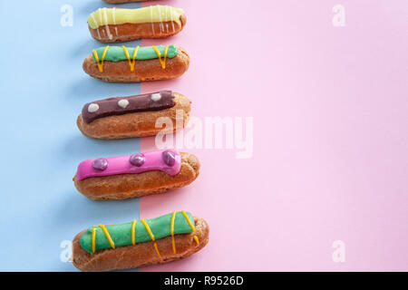 Eclairs on pink-blue background with copy space Stock Photo