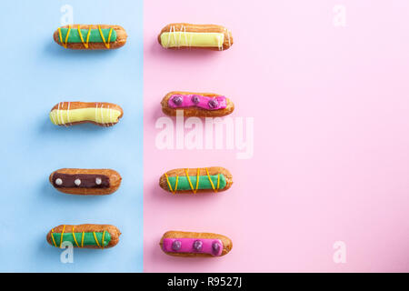 Two rows of colorfully decorated eclairs with copy space Stock Photo