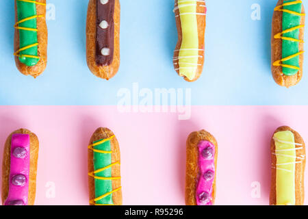 Closeup of colorful decorated eclairs on pink-blue background Stock Photo