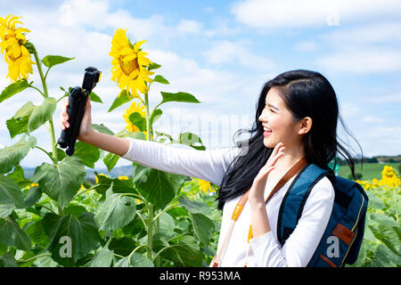 asiaAsian young woman visit sunflower field - Image Stock Photo