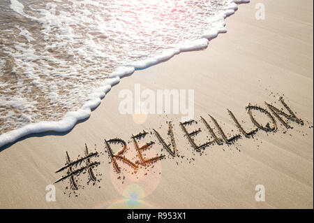 Message for Reveillon (a French word for awakening that represents New Year's Eve in Brazil) written in sand with a social media hashtag on the beach Stock Photo