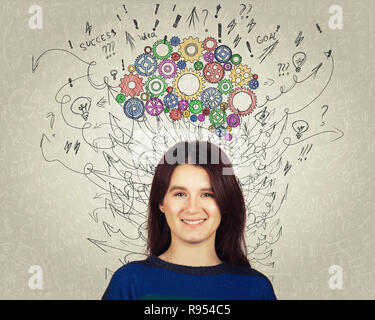 Close up portrait of a young woman with colorful gear brain above head. Happy emotion, positive thinking with arrows and curves as thoughts. Concept f Stock Photo