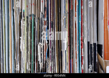 A pile of old worn magazines stacked on a shelf Stock Photo