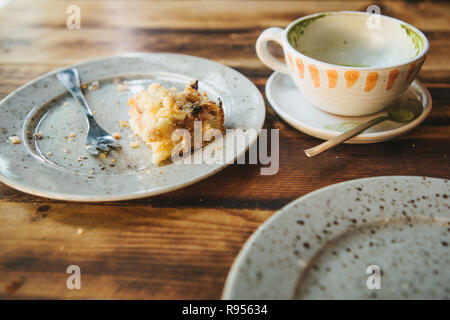 A dirty plate and an empty cup of coffee. The half-eaten cupcake on a plate. Empty dishes after eating Stock Photo