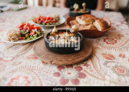 dish with mushrooms and white sauce in bowl on wooden stand. Restaurant menu. Traditional Turkish food. Stock Photo