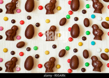 Easter background with chocolate candies in the shape of rabbit, chicken, eggs and sweets. Chocolate easter eggs. Flat lay. View from above Stock Photo