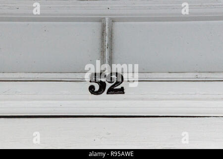 The house number 52 on a white painted door frame in Hertfordshire. Stock Photo