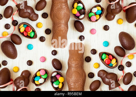 Easter background with chocolate candies in the shape of rabbit, chicken, eggs and sweets. Chocolate easter eggs. Flat lay. View from above Stock Photo