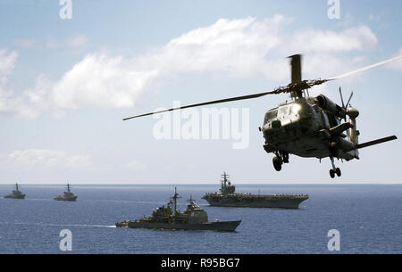 An HH-60H Seahawk assigned to the 'Black Knights' of Helicopter Anti-Submarine Squadron Four (HS-4) flies over the Ronald Reagan CSG. U.S. Navy photo by Mass Communication Specialist 2nd Class Aaron Burden Stock Photo