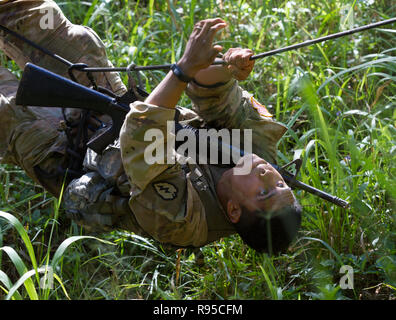 A U.S. Army soldier with the 25th Infantry Division completes a backwards rope crawl hanging upside down during Tropic Lightning Week at Schofield Barracks December 17, 2018 in Honolulu, Hawaii. Stock Photo