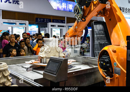 Industrial robot carving and engraving plaster pedestal at tech fair in Shenzhen, China Stock Photo