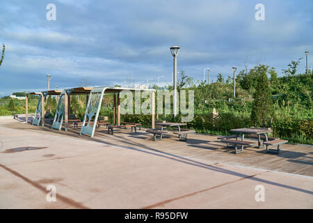 wooden benches with gazebo and tables in a park Stock Photo