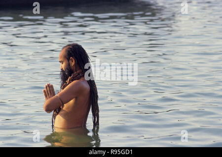 Sadhu doing surya namaskar in ganga water, varanasi, uttar pradesh, india Stock Photo