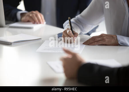 Close up female hands affirming contract with signature during m Stock Photo