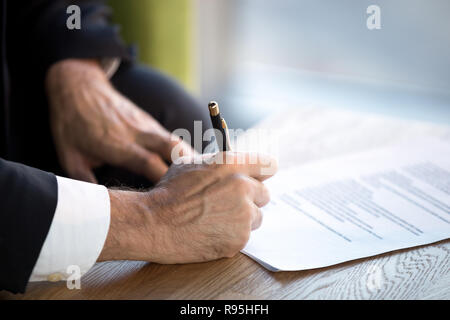 Close up male hands puts his signature on official document Stock Photo