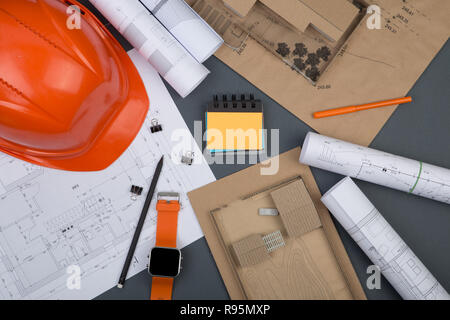Workplace of architect - helmet, construction drawings, watch on grey background Stock Photo