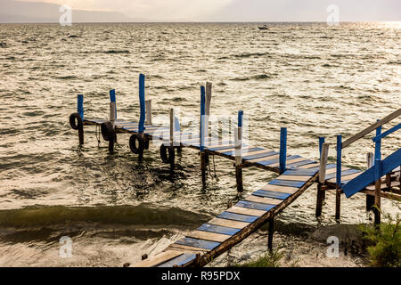 Wooden jetty in golden late afternoon light on Lake Atitlan in the Guatemalan highlands Stock Photo