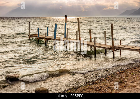 Wooden jetty in golden late afternoon light on Lake Atitlan in the Guatemalan highlands Stock Photo