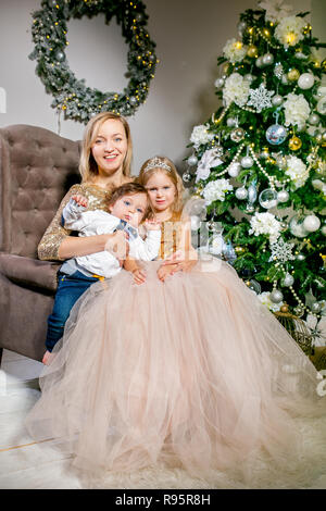 Happy family mother son and daughter in luxurious dresses near