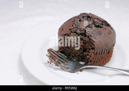 Partially Eaten Chocolate Muffin With A Fork On A White Background Stock Photo