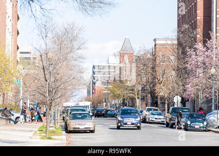 Washington DC, USA - April 5, 2018: Residential area, apartment buildings, street in northwest of district of columbia, road with people walking in sp Stock Photo