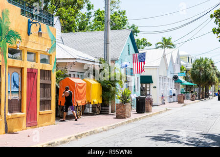Key West, USA - May 1, 2018: Colorful red, orange, yellow building of Blue Macaw restaurant, bar, cafe in Florida keys on sunny day, man, person, peop Stock Photo