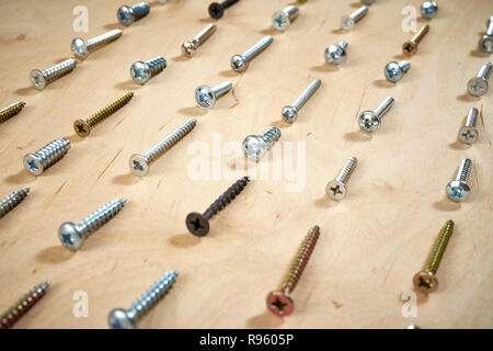 pattern background of various screws on a  wooden work table Stock Photo