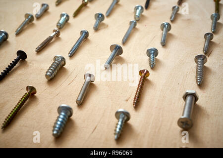 pattern background of various screws on a  wooden work table Stock Photo