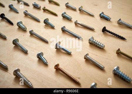 pattern background of various screws on a  wooden work table Stock Photo