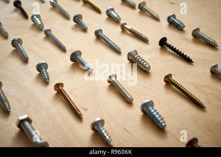 pattern background of various screws on a  wooden work table Stock Photo