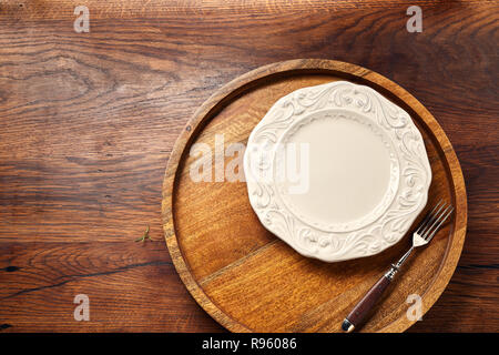 Empty white blank plate with fork on wooden background with copy space. Top view. Stock Photo