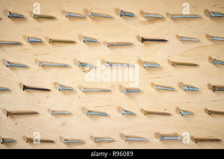 pattern background of various screws on a  wooden work table Stock Photo