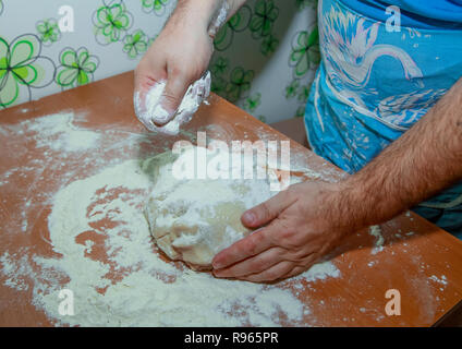 The man on the table kneads the dough for baking. Stock Photo