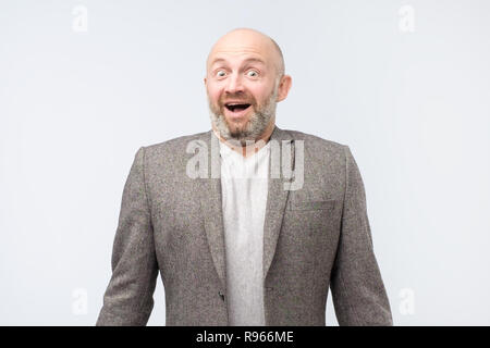 Attractive surprised bearded man standing with opened mouth. Stock Photo