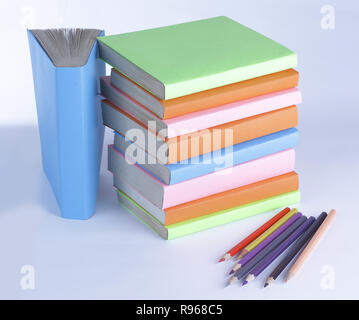 colored pencils and stack of books on white background. photo wi Stock Photo