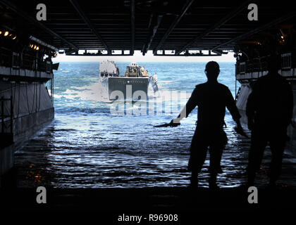 U.S. Navy sailors guide a Landing Craft Utility boat into the flooded well deck of the USS Kearsarge (LHD 3) to offload equipment and supplies as the ship operates in the Atlantic Ocean. DoD photo by Seaman Christopher Newsome, U.S. Navy
