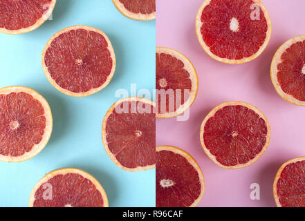 Creative background made of cut coral color grapefruits on pink and blue background. Flat lay style. Stock Photo