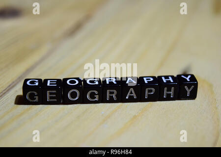 Geography written on wooden blocks. Inspiration and motivation concepts. Cross processed image on Wooden Background Stock Photo