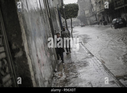 December 20, 2018 - Gaza City, The Gaza Strip, Palestine - Palestinians are seen walking on a street flooded during a heavy rainfall at the Jabalya refugee camp in Gaza Strip. (Credit Image: © Mahmoud Issa/SOPA Images via ZUMA Wire) Stock Photo